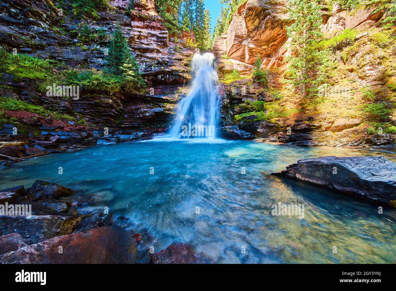 Eau pure bleue de la cascade dans le canyon caché des montagnes Banque D'Images