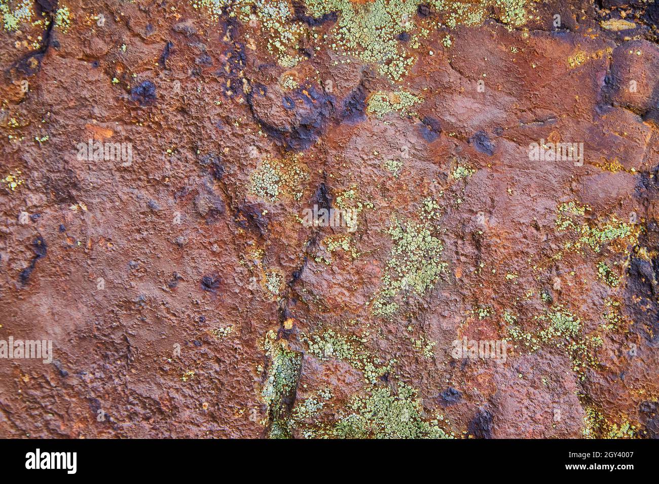 Texture de la paroi rocheuse de rouge avec des taches de lichen Banque D'Images