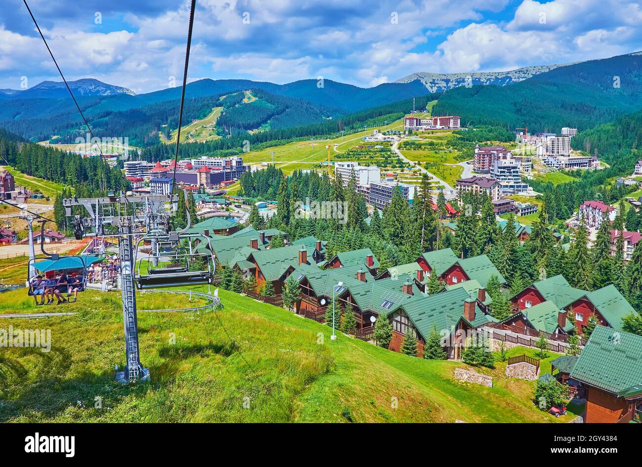 La remontée mécanique surmonte la pente abrupte de la montagne Bukovel avec une vue sur la vallée avec des hôtels, des cottages, des forêts et des paysages de montagne, des Carpates, Banque D'Images