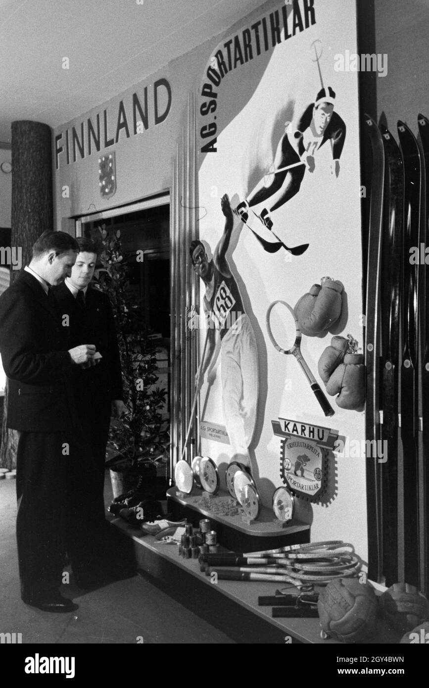 Zwei vor einem Stand Besucher mit Export finnischen auf der Leipziger Frühjahrsmesse, Deutschland 1941. Deux visiteurs devant un stand d'articles de sport sur le finlandais Leipziger Frühjahrsmesse, Allemagne 1941. Banque D'Images