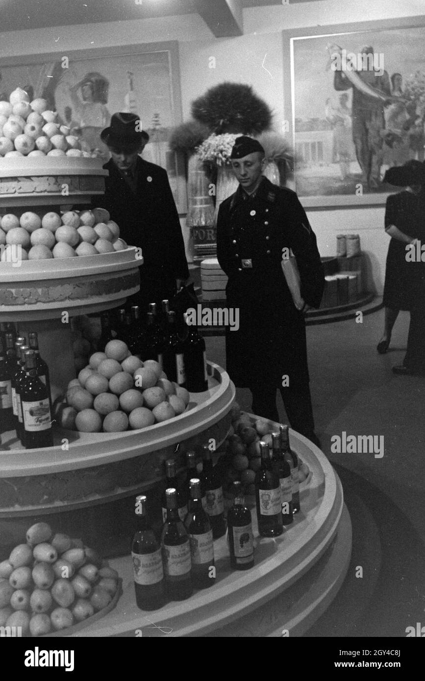 Besucher der Leipziger Frühjahrsmesse vor einem Messestand mit Spezialitäten, südländischen Deutschland 1941. Les visiteurs de la Leipziger Frühjahrsmesse en face du stand avec délicatesse de la Méditerranée, de l'Allemagne 1941. Banque D'Images