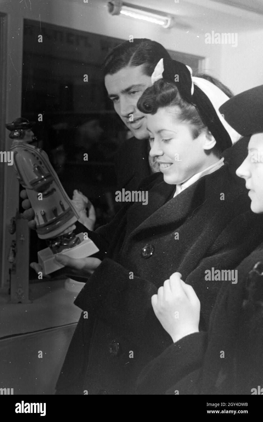 Besucher der Wiener Modewoche, im Haus der mode 'Palais Lobkowitz', betrachten ungarisches Kunsthandwerk; Deutschland 1940er Jahre.Visiteurs de la semaine de la mode de Vienne, dans la maison de la mode 'Palais Lobkowitz', regardant l'art et l'artisanat hongrois; Allemagne années 1940. Banque D'Images