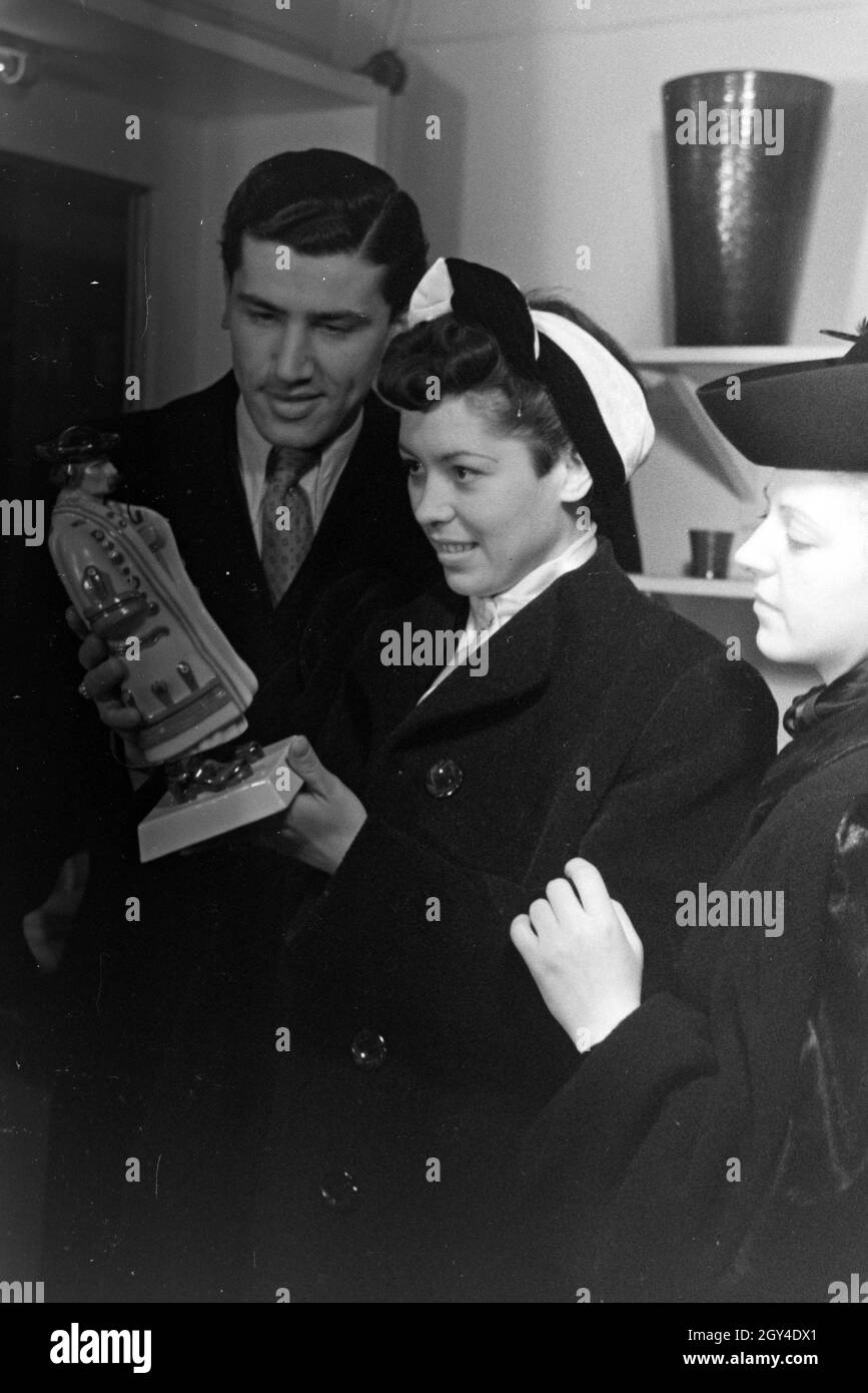 Besucher der Wiener Modewoche, im Haus der mode 'Palais Lobkowitz', betrachten ungarisches Kunsthandwerk; Deutschland 1940er Jahre.Visiteurs de la semaine de la mode de Vienne, dans la maison de la mode 'Palais Lobkowitz', regardant l'art et l'artisanat hongrois; Allemagne années 1940. Banque D'Images