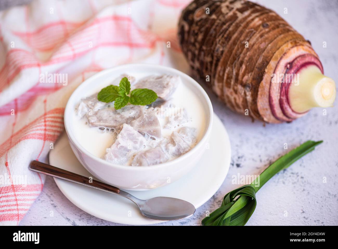 Taro alimentaire avec dessert taro bouilli avec du sucre et du lait de coco sur un bol et de la racine de taro frais cru bio prêt à cuire, cuisine thaïlandaise asiatique Banque D'Images