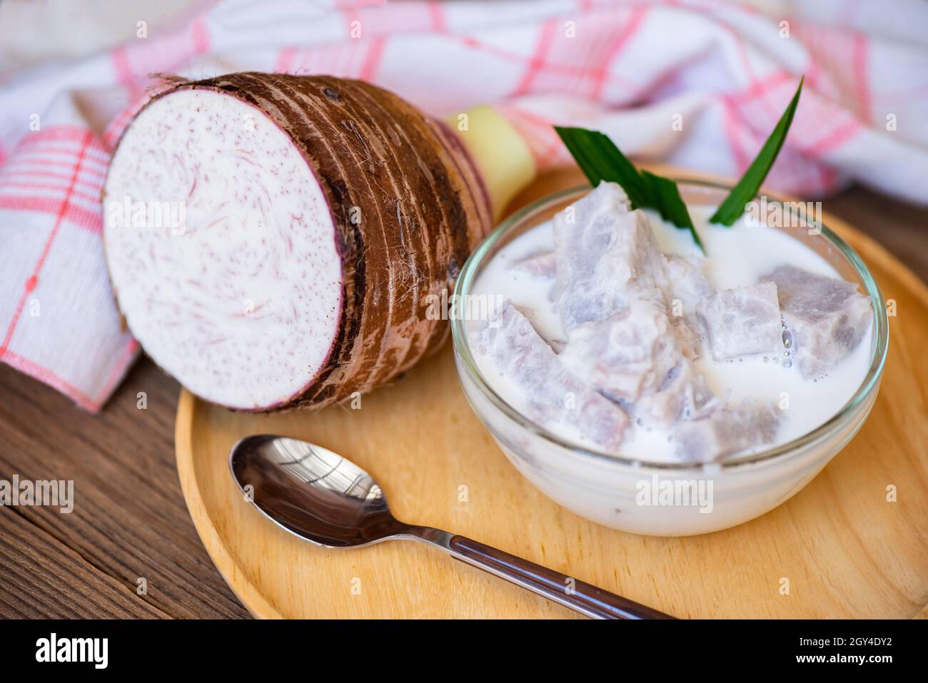 Taro alimentaire avec dessert taro bouilli avec du sucre et du lait de coco sur un bol et de la racine de taro frais cru bio prêt à cuire, cuisine thaïlandaise asiatique Banque D'Images