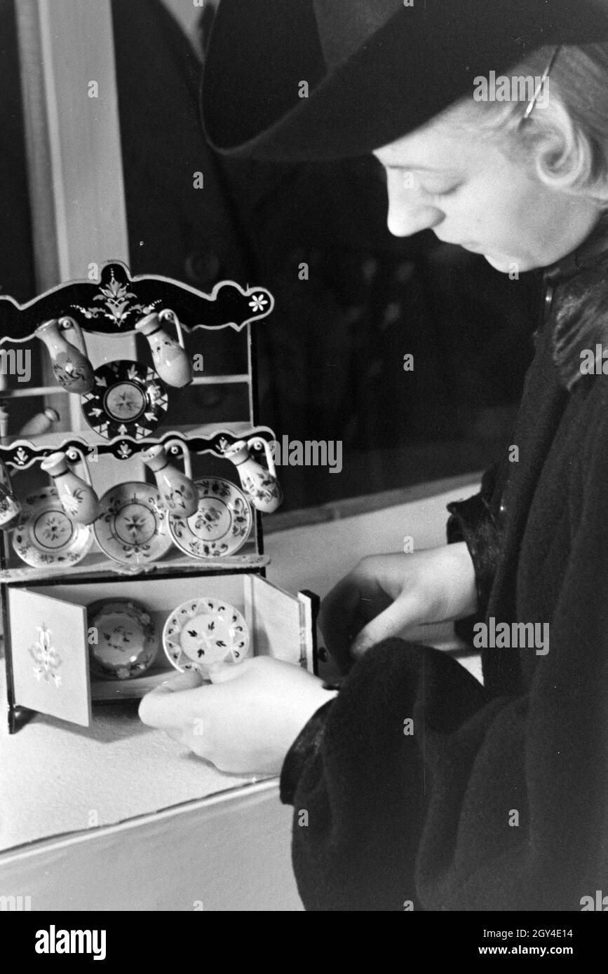 Besucher der Wiener Modewoche, im Haus der mode 'Palais Lobkowitz', betrachten ungarisches Kunsthandwerk; Deutschland 1940er Jahre.Visiteurs de la semaine de la mode de Vienne, dans la maison de la mode 'Palais Lobkowitz', regardant l'art et l'artisanat hongrois; Allemagne années 1940. Banque D'Images