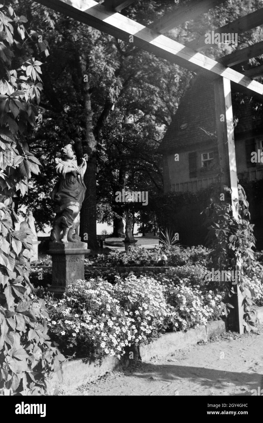 Eine barocke Statue inmitten von einem blühenden Blumenbeet Besucher lädt zum Verweilen un, Rothenburg ob der Tauber, Allemagne Allemagne Années 1930 er Jahre. Une statue au milieu d'un baroque lit floraison de fleurs encourage les visiteurs à s'attarder, Rothenburg ob der Tauber, Allemagne 1930. Banque D'Images