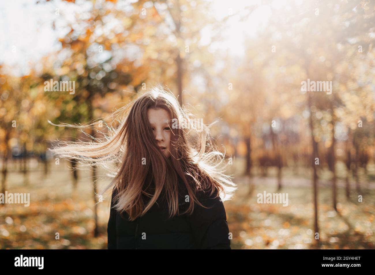 jeune fille adolescente marchant dans le parc d'automne. belle fille aux cheveux coulant se tient sur fond d'érable doré Banque D'Images