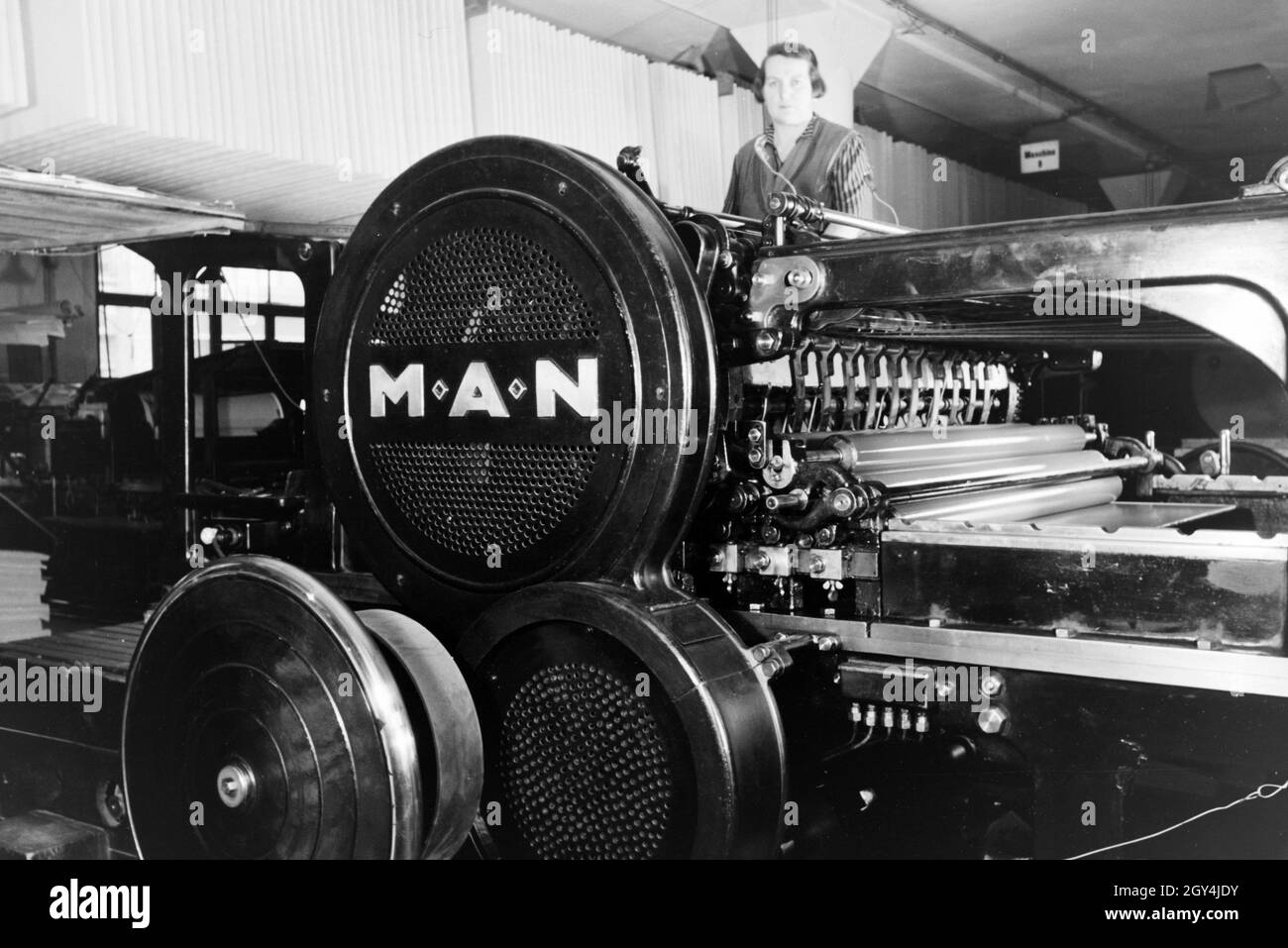 Eine die Arbeiterin kontrolliert Rotationsdruckmaschine Maschinenbaukonzerns in den Werken des MAN (Maschinenfabrik Augsburg-Nürnberg), Deutschland 1930 er Jahre. Un travailleur le contrôle de la presse d'impression rotative dans les usines de la société d'ingénierie mécanique (homme), Maschinenfabrik Augsburg-Nürnberg Allemagne 1930. Banque D'Images