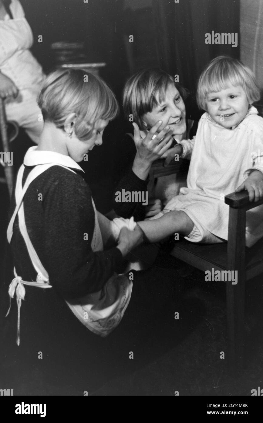 Vierlinge von Brücken der Zwei sich kümmern um ihr jüngstes Geschwisterkind, Deutsches Reich 1930er Jahre. Deux des quadruplets de Brücken à leur plus jeune sœur, après l'Allemagne des années 1930. Banque D'Images