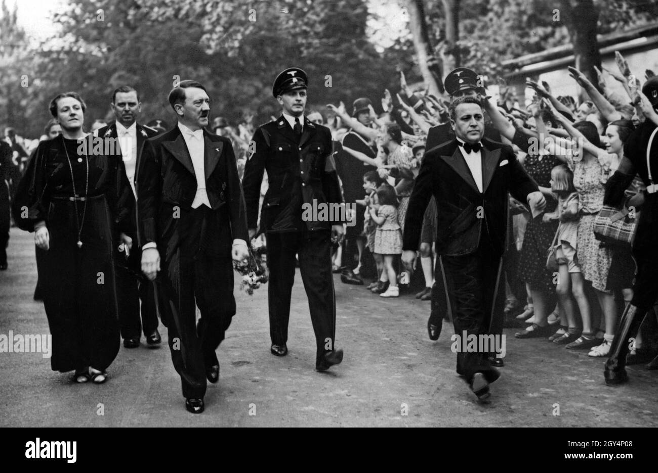 Le directeur du festival et le loyaliste d'Hitler Winifred Wagner, l'aide de camp d'Hitler Julius Schaub et Adolf Hitler marchent devant une foule enthousiaste.Wagner est resté publiquement fidèle à Hitler après la guerre comme un ancien nazi.[traduction automatique] Banque D'Images