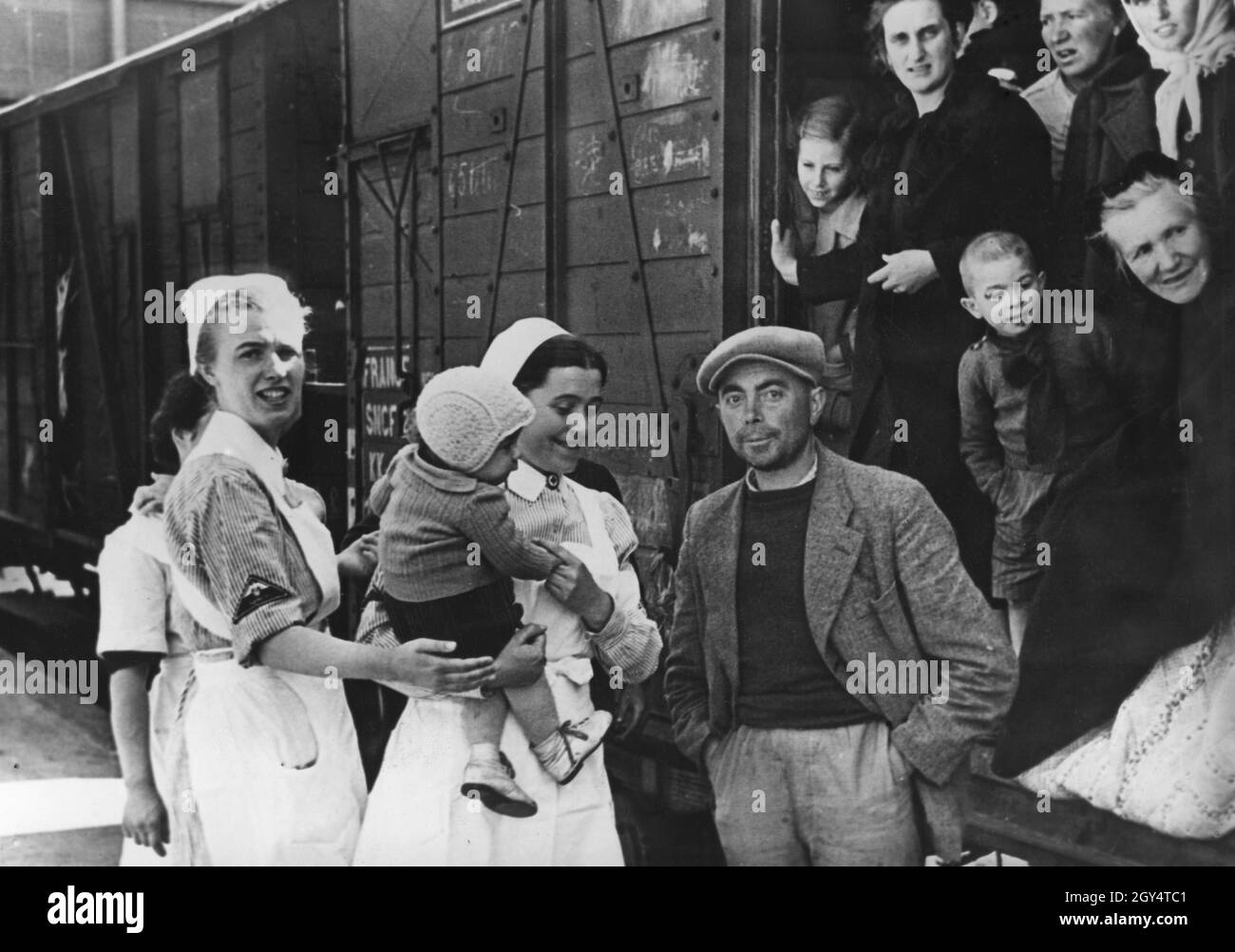 « une fois évacués par le gouvernement français, les alsaciens et les Loriers sont maintenant transportés vers la région annexée par les Allemands.La propagande nazie écrit au dos de la photo: ''les Français dans le territoire inoccupé ont laissé les Alsatians de retour sentir leur haine jusqu'à la fin. De la manière la plus indigne, les rapatriés ont été entassés dans des wagons de bétail et transportés à leur patrie.Notre photo montre l'arrivée d'un train de transport de rapatriés alsaciens qui ont également dû faire le voyage en wagons de bétail.''[traduction automatique]' Banque D'Images