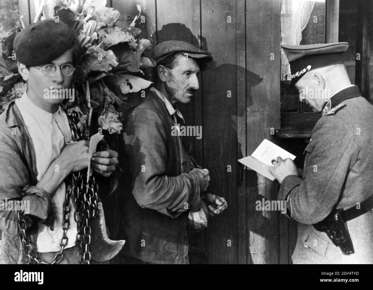 Gardes-frontières à la ligne de démarcation entre le nord et le sud de la France : un soldat vérifie les cartes d'identité de deux ouvriers agricoles.[traduction automatique] Banque D'Images