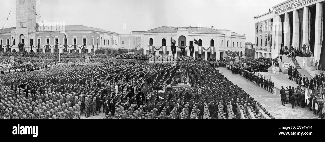 'Benito Mussolini (dans la tribune de droite) a prononcé un discours devant les soldats et les habitants de Littoria (aujourd'hui Latina) sur la Piazza del Popolo le 27 octobre 1941, l'anniversaire de la 'arche de Rome'.Dans son discours, il a promis trois mille paysans et anciens combattants des terres et des champs issus de la réhabilitation des marais Pontines.L'hôtel de ville se trouve à gauche de la place.[traduction automatique]' Banque D'Images