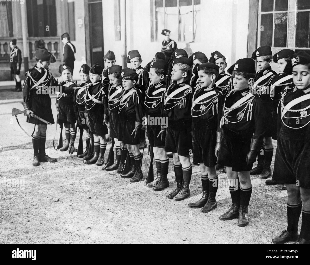 "Dans l'Opéra fasciste Nazionale Balilla, même les jeunes garçons âgés de six à huit ans, le soi-disant ''Figli della lupa'' (Wolf Children), ont été forés militairement.Dans la photo, prise en septembre 1928, un garçon légèrement plus âgé de Balilla montre aux nouveaux membres comment se tenir à l'attention.[traduction automatique]' Banque D'Images