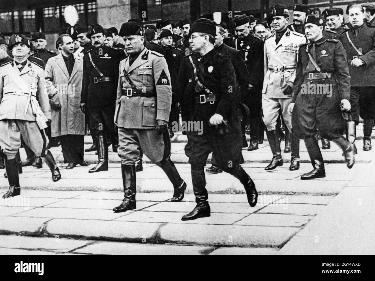 "Le 28 octobre 1935, le 13ème anniversaire du fasciste 'Marque on Rome', Benito Mussolini, dirigeant du Partito Nazionale Fascista, a traversé Rome pour inaugurer une série de nouveaux bâtiments publics à Rome.Ici il descend les marches du Palazzo delle poste e Telegrafi (aujourd'hui Palazzo delle poste Roma Ostiense) sur la via Marmorata, qu'il a inaugurée plus tôt.Il était accompagné de nombreux anciens camarades fascistes.[traduction automatique]' Banque D'Images