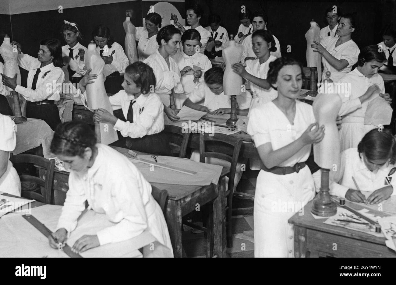 Une classe de filles d'une école italienne conçoit des robes de femmes en classe d'art.La photo a été prise en 1937.[traduction automatique] Banque D'Images