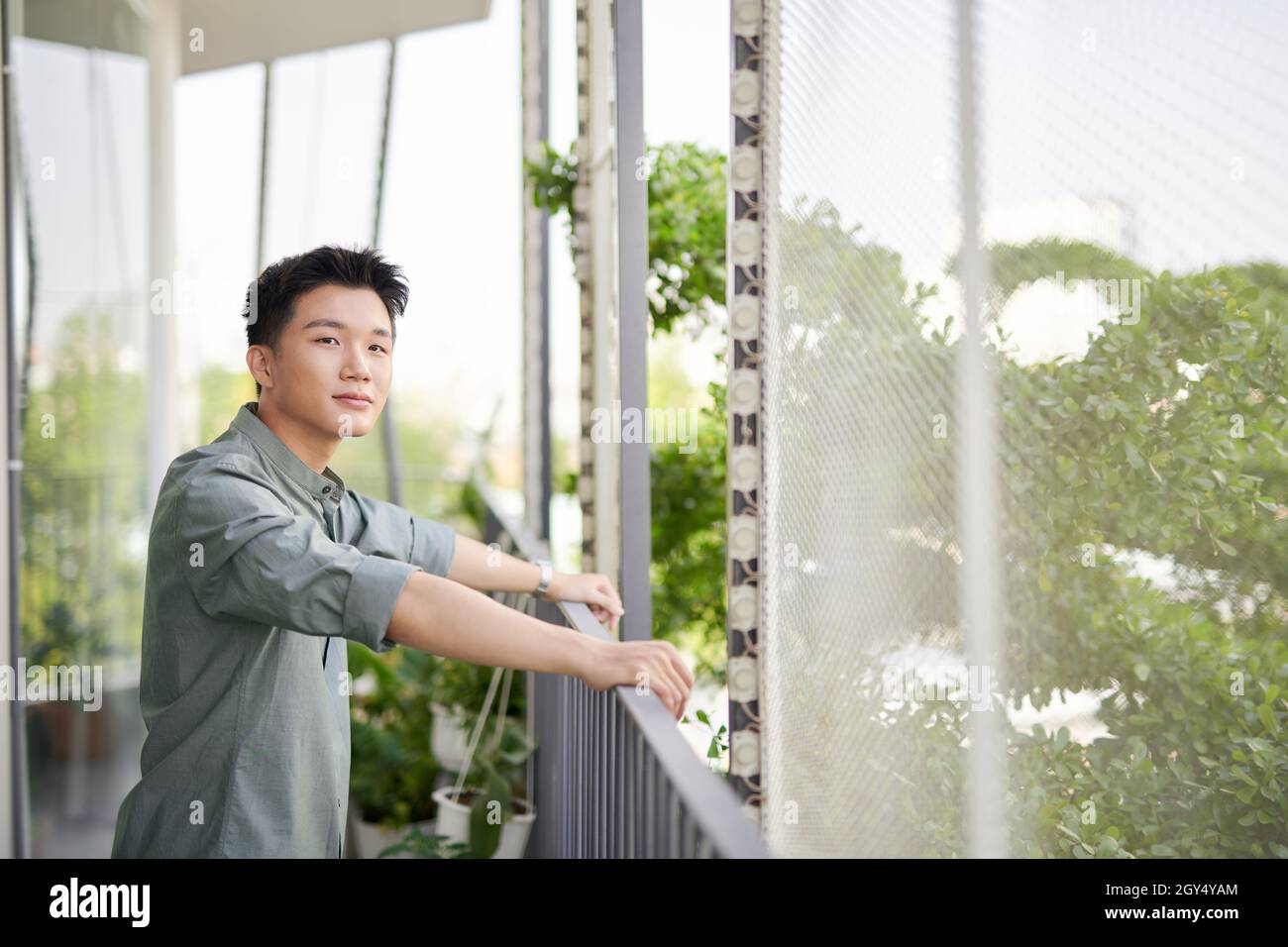 Demi-longueur de jeune homme beau debout sur un balcon extérieur, Banque D'Images