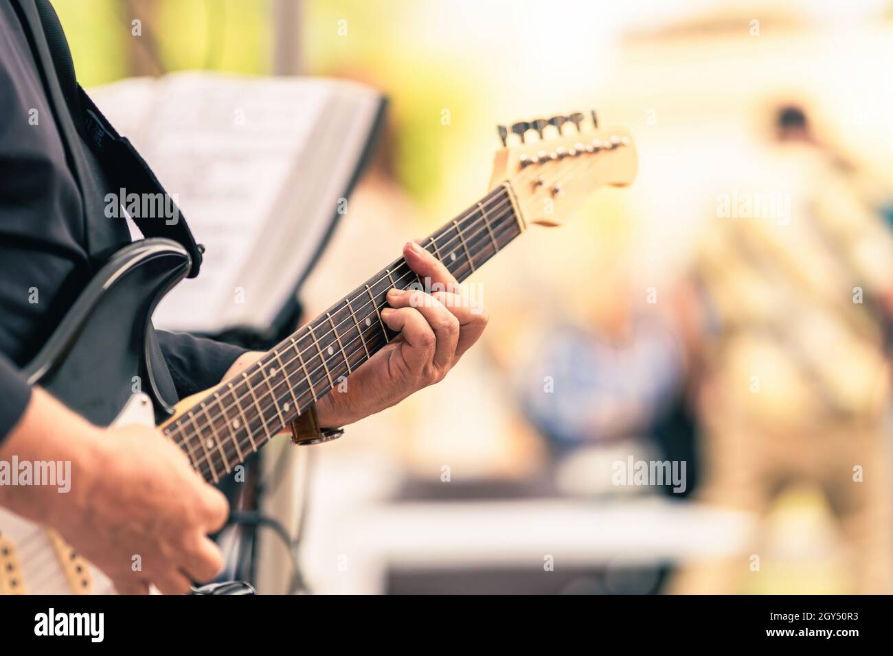 Mains d'un musicien jouant une guitare électrique dans un concert Banque D'Images