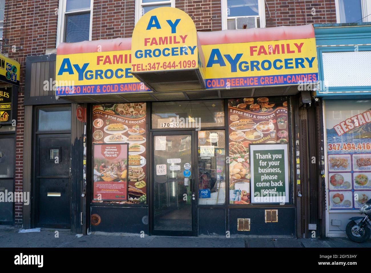 L'extérieur du magasin d'alimentation AY Family situé sur Jamaica Avenue à Queens, New York.Au service d'une population diversifiée, les signes sont en 3 langues Banque D'Images