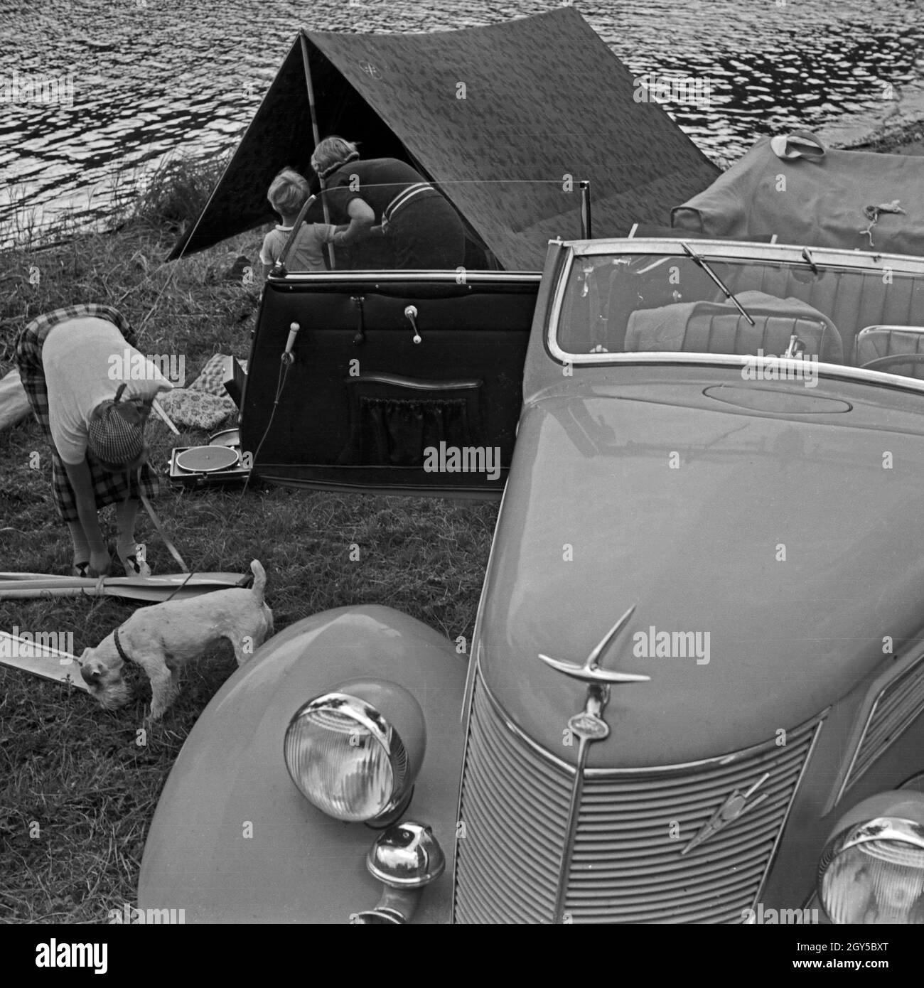 Zwei Frauen die packen Campinausrüstung zusammen dans un Ford V8 nach einem Tag am See, Deutschland 1930 er Jahre. Deux femmes l'emballage du matériel de camping dans une Ford V8 après un jour de vacances au bord d'un lac, l'Allemagne des années 1930. Banque D'Images