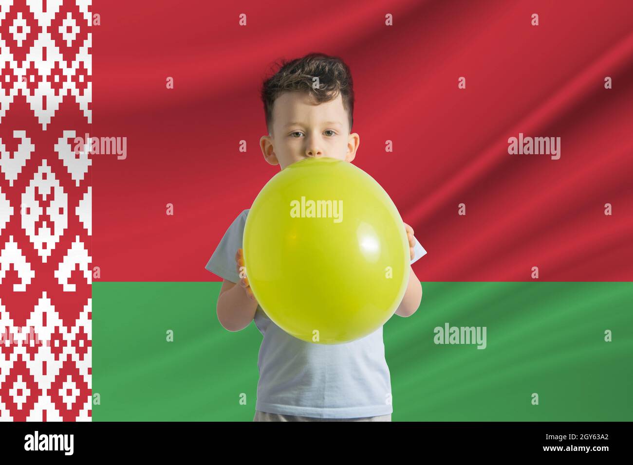 Journée des enfants en Biélorussie. Garçon blanc avec un ballon sur le fond du drapeau de la Biélorussie. Concept de fête des enfants. Banque D'Images