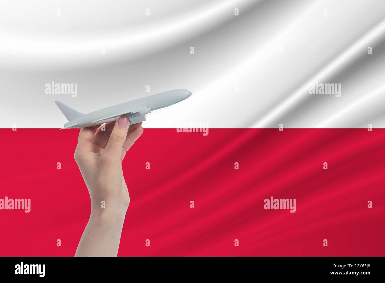 Avion en main avec le drapeau national de la Pologne. Voyage en Pologne. Banque D'Images