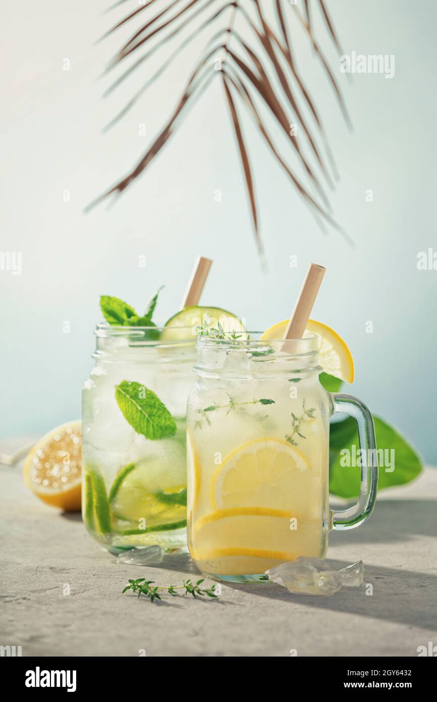 Limonade et mojito sur fond bleu ciel. Cocktails maison rafraîchissants, boissons estivales, sélection. Ombres ensoleillées Banque D'Images