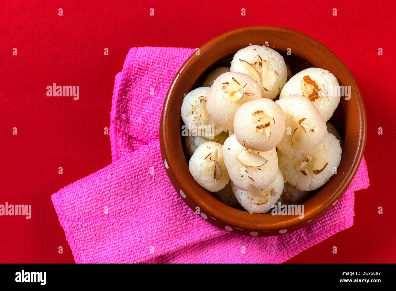 Indian Sweet ou Dessert - Rasgulla, Bengali célèbre bonbon en cuvette d'argile avec serviette sur fond rouge Banque D'Images