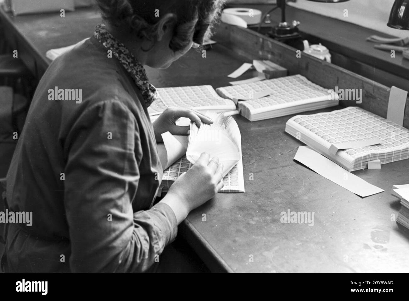 Eine der/Reichsdruckerei zählt Dauerserie Hindenburg en 2013 à Berlin, Deutschland Bögen 1930er Jahre. Une femme membre du personnel de l'usine d'impression Reichsdruckerei de comptage à Berlin, Allemagne Hindenburg Planches de Timbres 1930. Banque D'Images