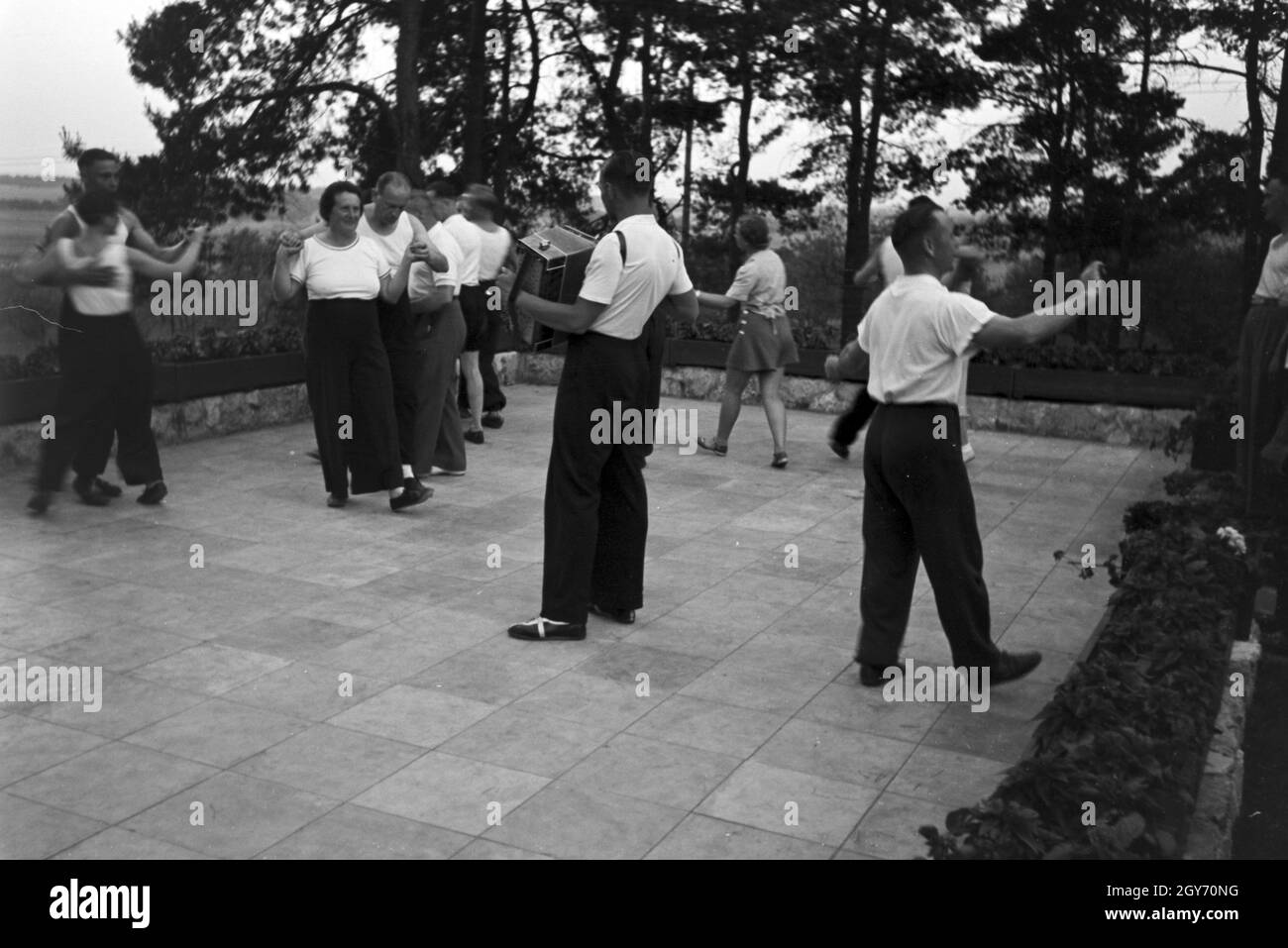 Tanz vor Waldhütten des KdF Sportheim Belzig dans der Mark Brandenburg, Deutschland 1930 er Jahre. Les gens danser en face de cabanes dans la forêt au sports club à Belzig à Brandebourg, Allemagne 1930. Banque D'Images