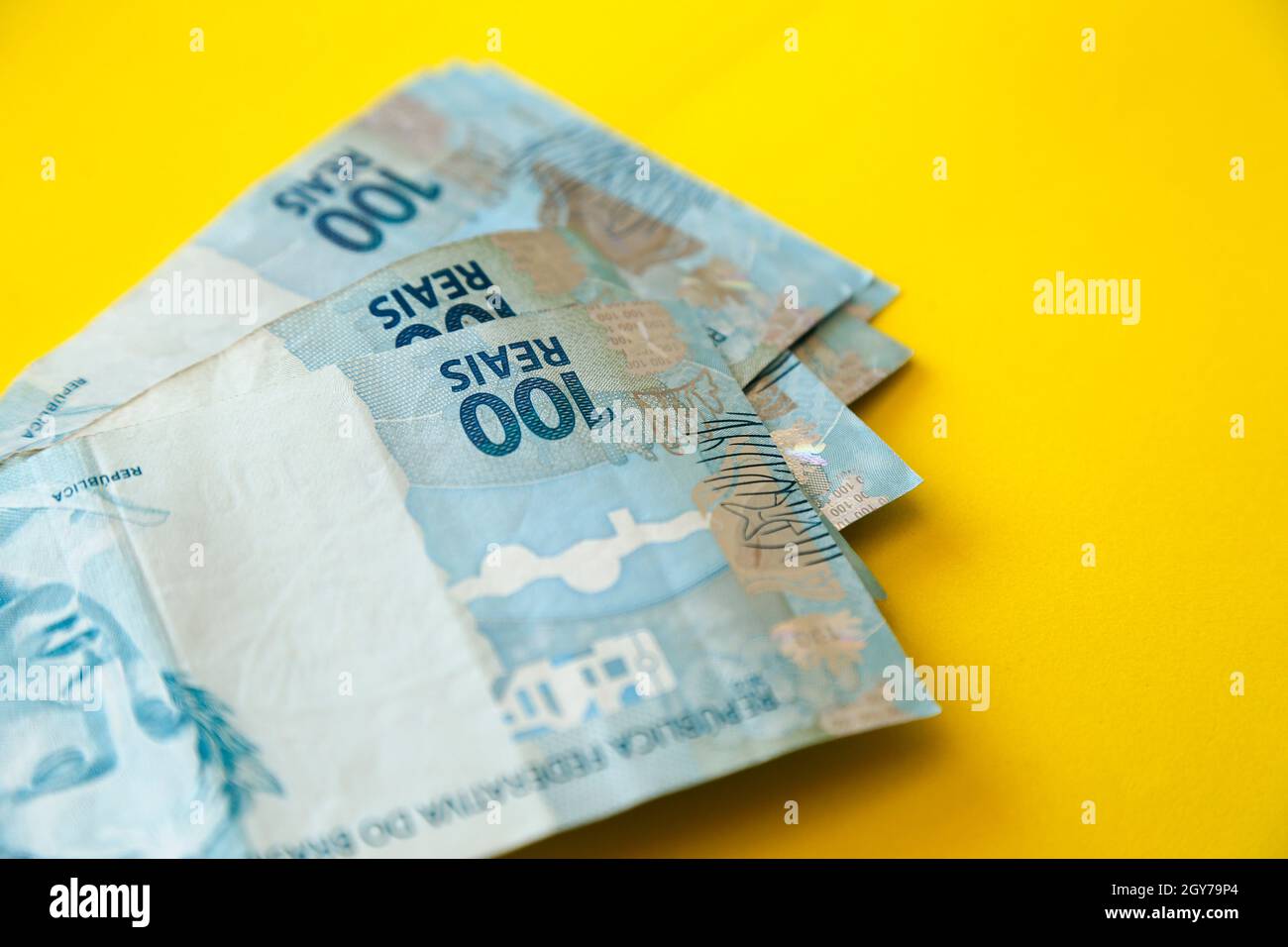 argent du brésil empilé sur la surface jaune - plusieurs centaines des factures réelles Banque D'Images