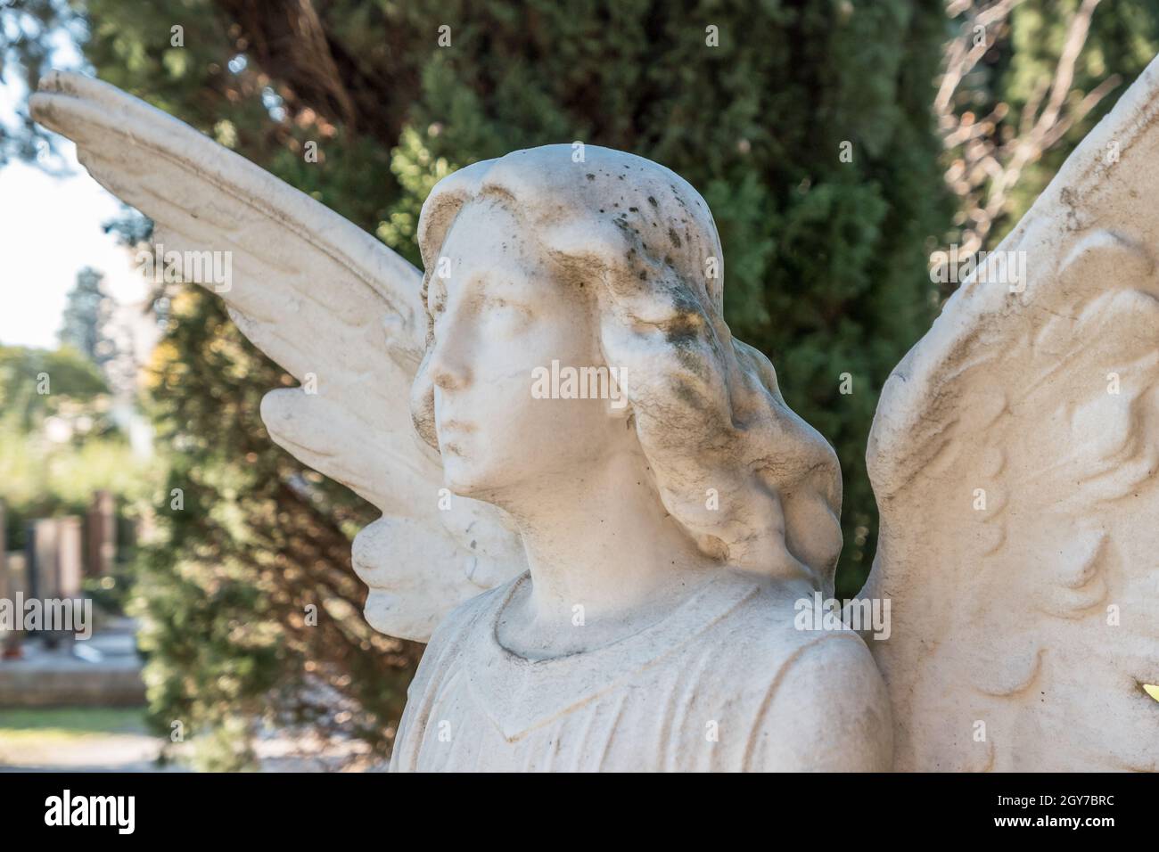 Statue d'époque d'un ange triste sur fond de feuilles Banque D'Images