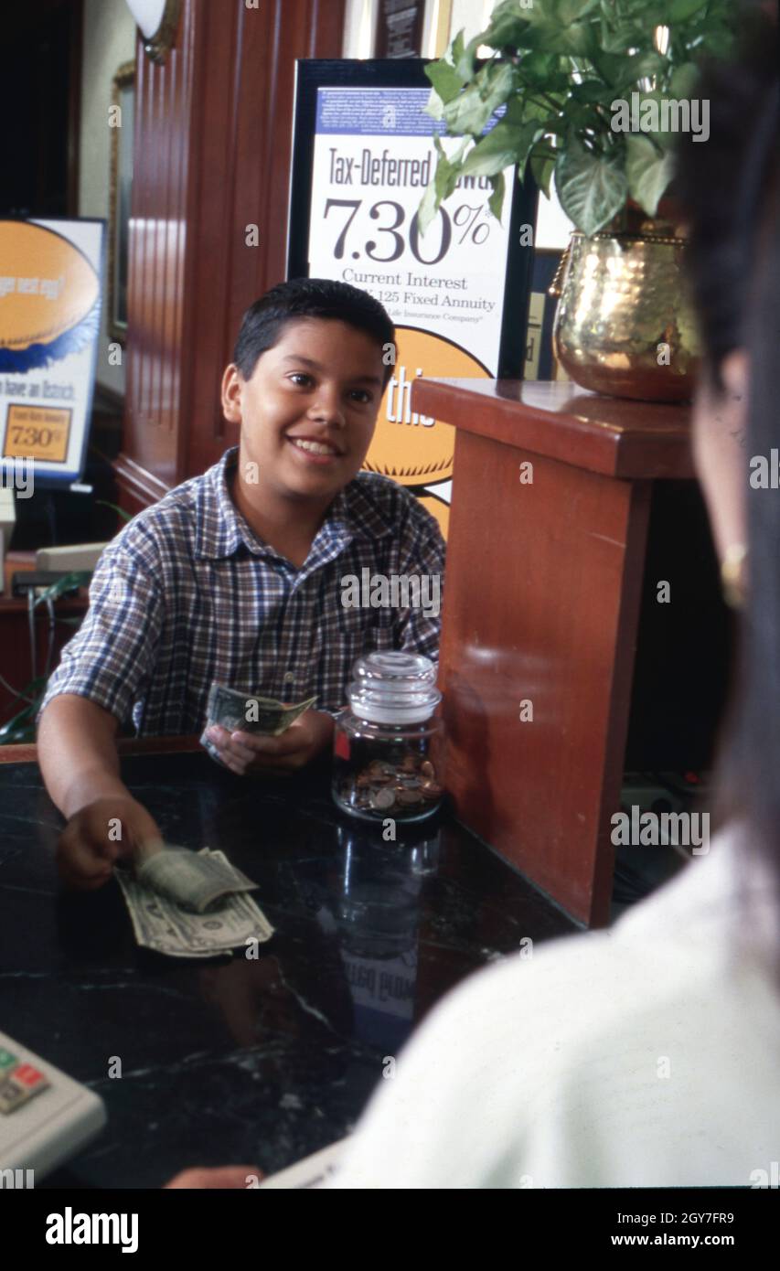 Austin Texas USA, septembre 1999 : un garçon hispanique de 12 ans ouvre un compte d'épargne pour enfants à la banque locale.©Bob Daemmrich Banque D'Images