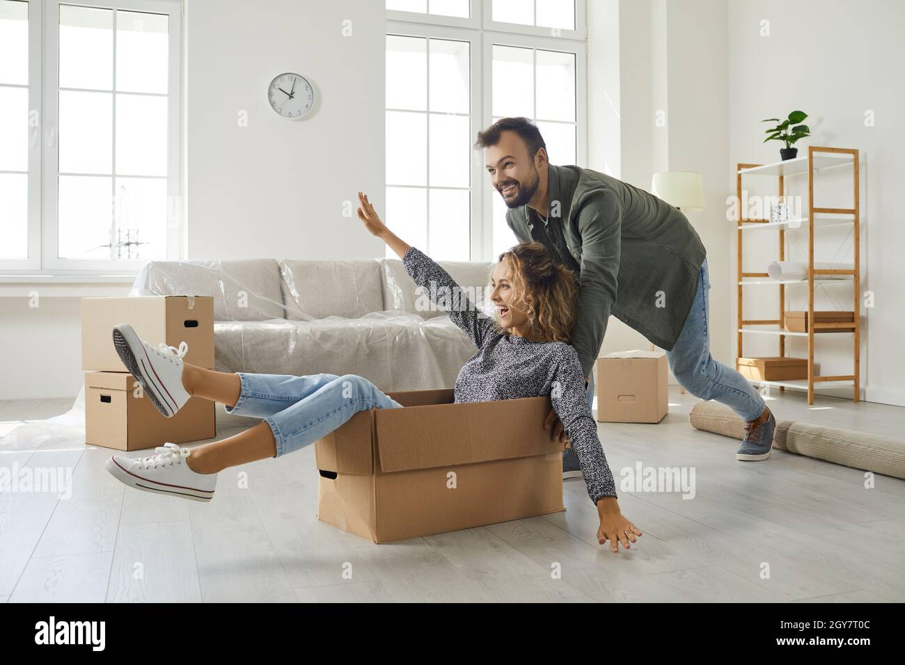 Un jeune couple heureux qui s'amuse dans la maison nouvellement achetée de son rêve le jour du déménagement Banque D'Images