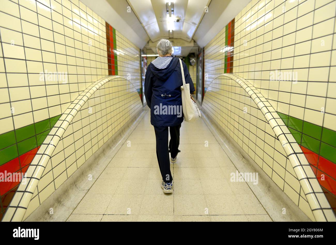Londres, Angleterre, Royaume-Uni.Femme marchant dans un tunnel dans une station de métro Banque D'Images