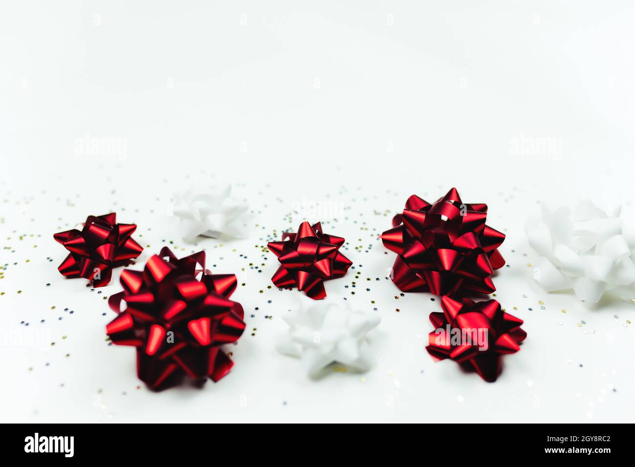 Fond de Noël avec noeuds rouges et blancs et paillettes.Photo de haute qualité Banque D'Images