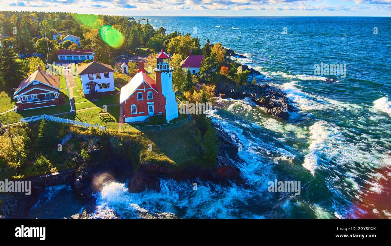 Antenne du phare d'Eagle Harbour avec forêt d'automne et vagues du lac en train de s'écraser et une lumière du soleil Banque D'Images