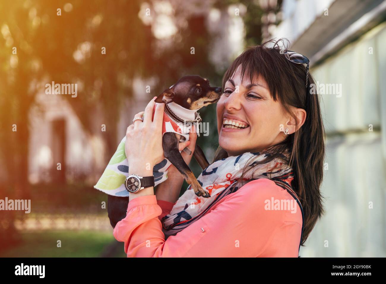 Bonne jeune femme caucasienne portant son petit chien, le russe Toy Terrier ou le russe Toy Terrier, vêtu d'un costume d'automne.Animaux de compagnie adorés Banque D'Images