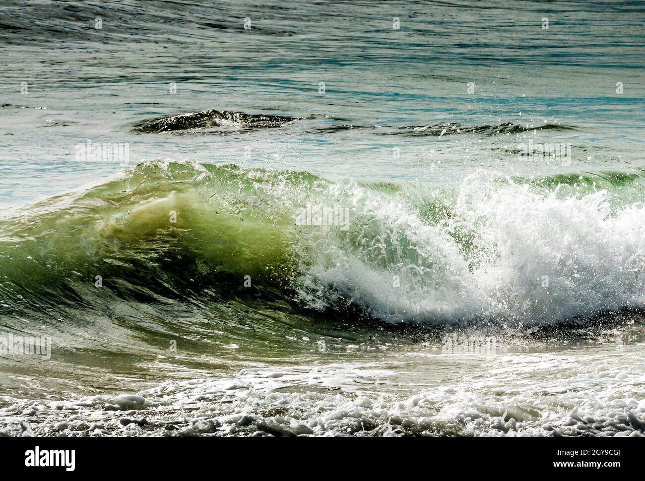 À mesure que la marée haute entre, les vagues se construisent et s'écrasont entre les rochers et le rivage, apportant plaisir à tout le monde et donnant un sens au mot paysage marin. Banque D'Images