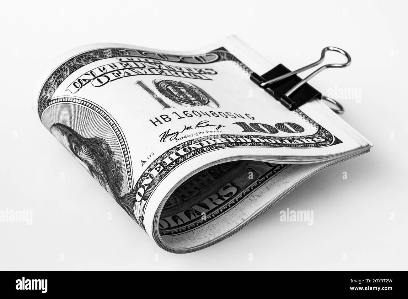 Une pile de dollars emballés sur un fond blanc.Une centaine de billets en dollars américains.Le tas de dollars est isolé avec une ombre.Noir et blanc s Banque D'Images