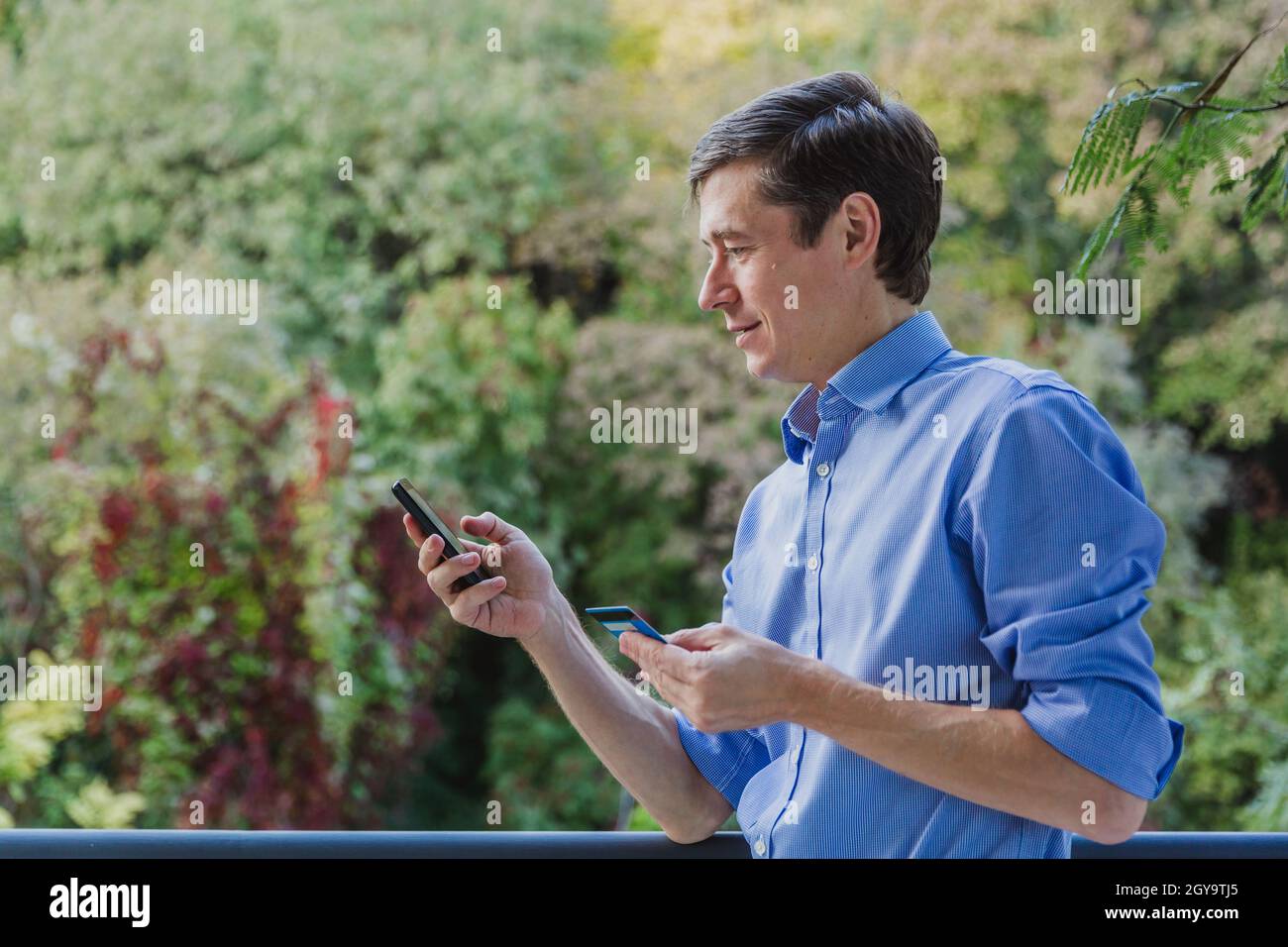 Paiement en ligne.Homme tenant une carte de crédit et utilisant un smartphone pour faire des achats sur Internet.Vente dans la boutique en ligne Banque D'Images