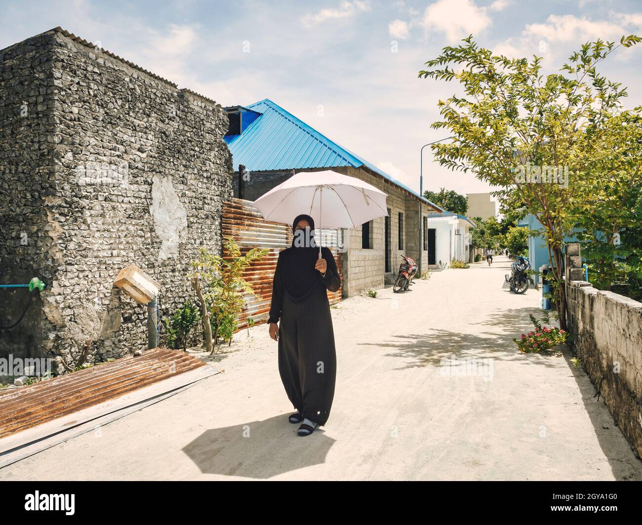 Femme dans la rue à l'île de Huraa, Maldives Banque D'Images