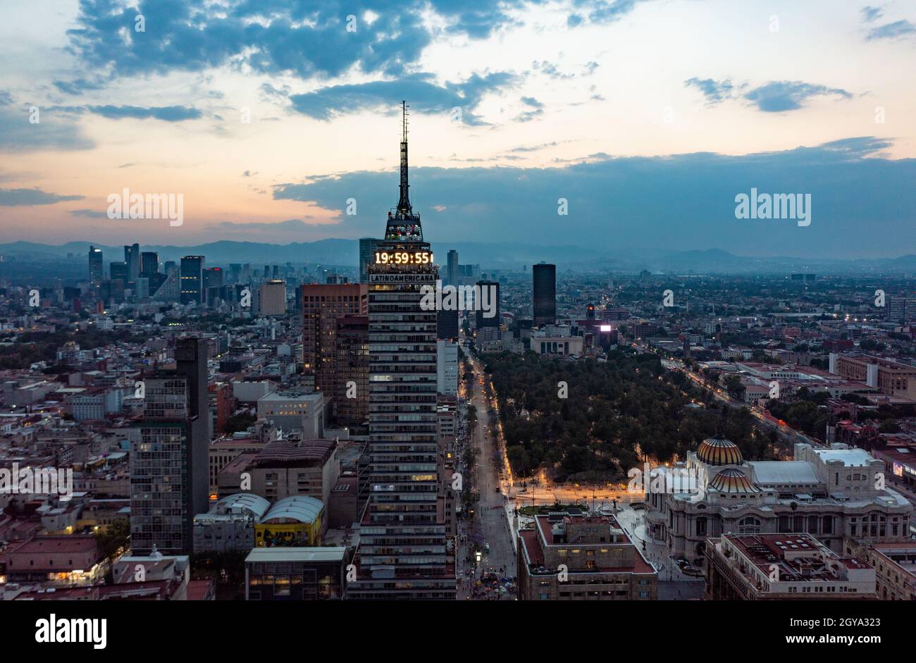 Vue aérienne des gratte-ciel financiers et des bâtiments résidentiels avec véhicule en mouvement dans la rue pendant la journée à Mexico sous bleu et orange nuageux sk Banque D'Images