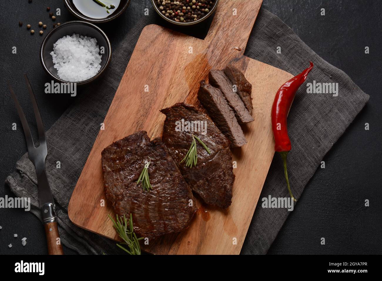 Steak de bœuf grillé juteux au romarin, viande frite, gros plan. Top Blade steaks sur bois Banque D'Images