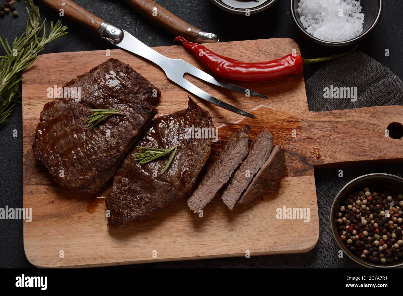 Steak de bœuf grillé juteux au romarin, viande frite, gros plan. Top Blade steaks sur bois Banque D'Images