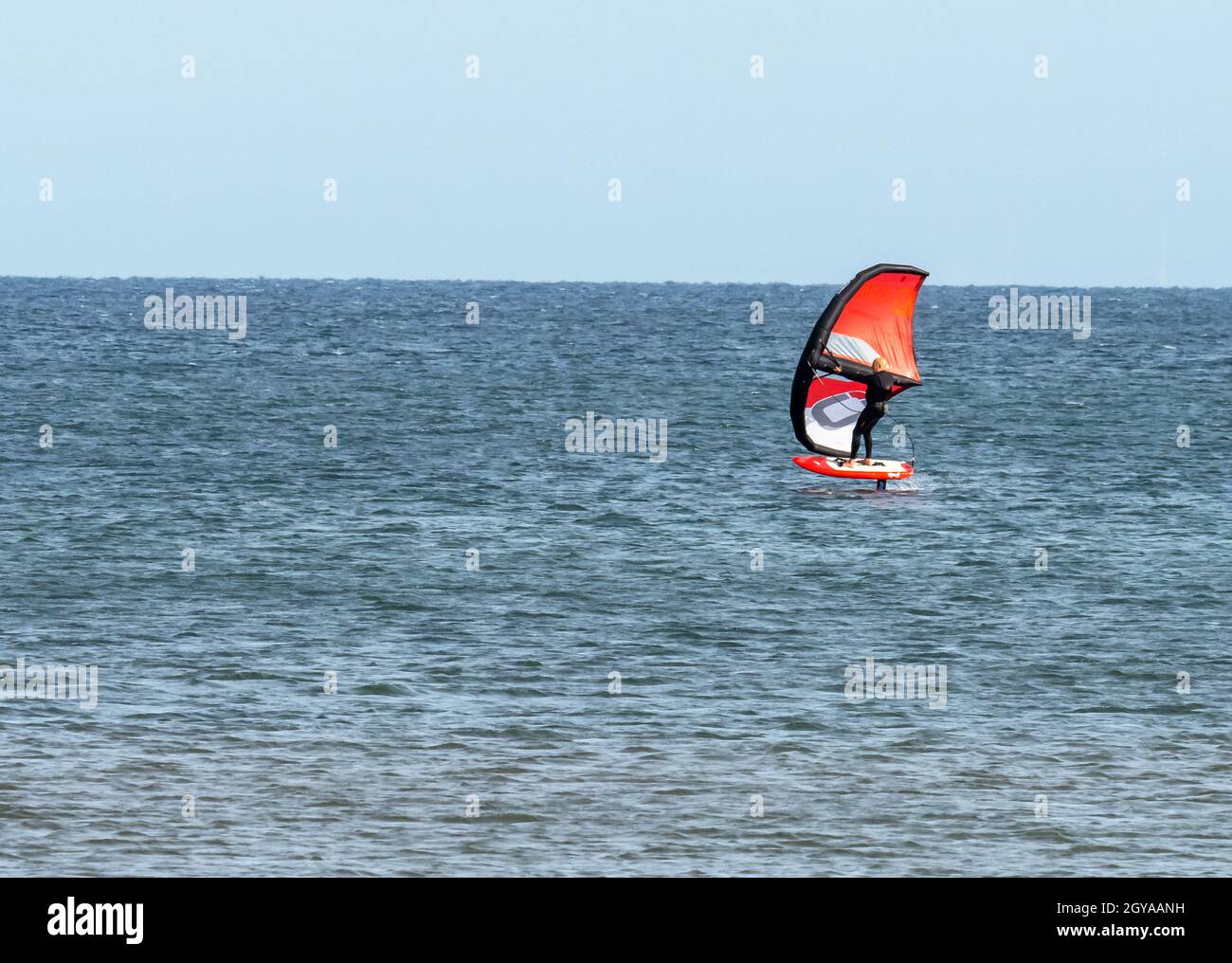 Un homme sur un hydroptère sur la mer à Titchwell, Norfolk, Royaume-Uni. Banque D'Images