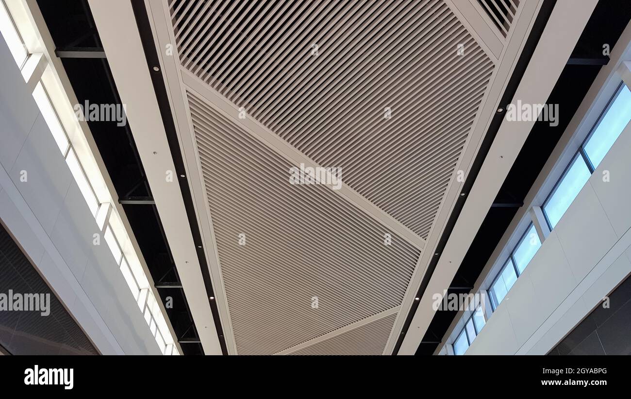 Finition plafond. Plafond suspendu blanc en treillis, décoration intérieure de bâtiments commerciaux. Intérieur au plafond dans un centre commercial avec éclairage Banque D'Images
