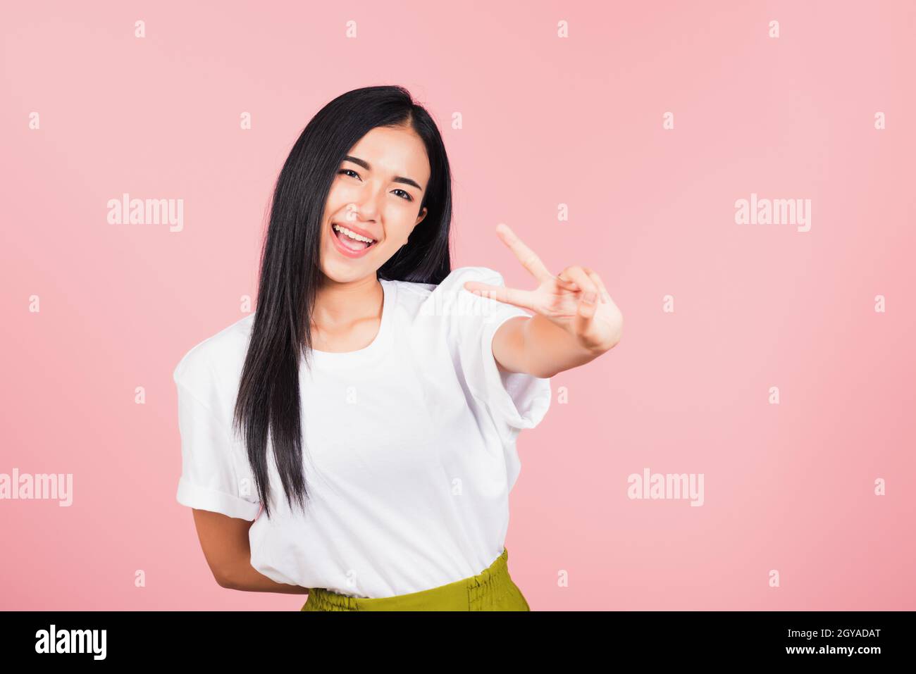 Asian heureux portrait beau mignon jeune femme adolescent sourire debout montrer doigt faire signe de victoire V-signe gestuel côté extérieur regardant le studio d'appareil photo Banque D'Images
