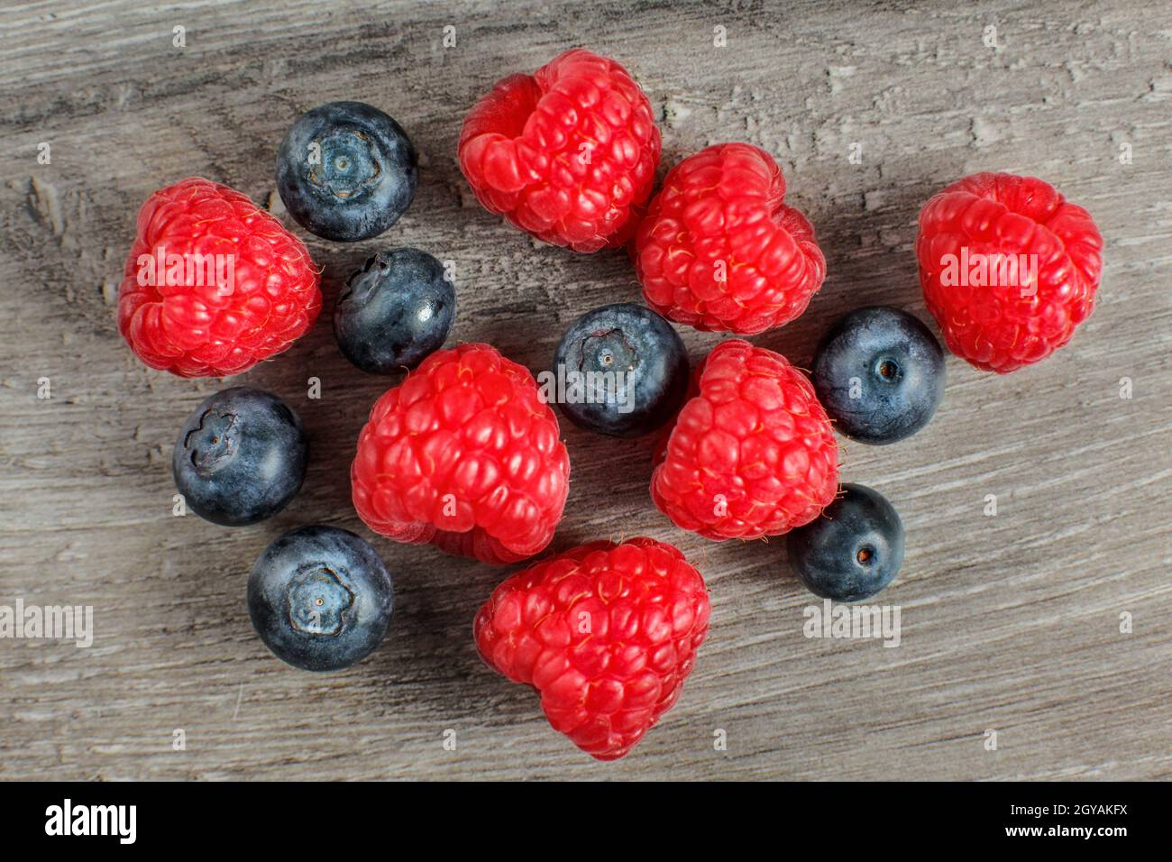 Vue sur table sur les framboises et les bleuets de couple mixte. Banque D'Images